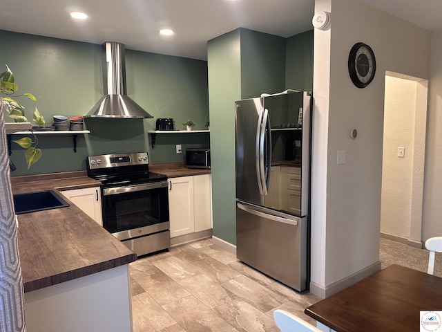 kitchen with open shelves, wall chimney range hood, white cabinets, stainless steel appliances, and a sink