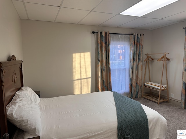 bedroom featuring a paneled ceiling and carpet floors