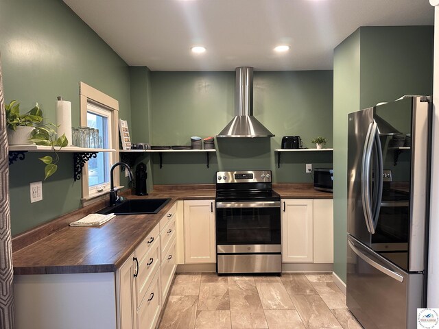 kitchen featuring open shelves, butcher block counters, appliances with stainless steel finishes, white cabinetry, and a sink