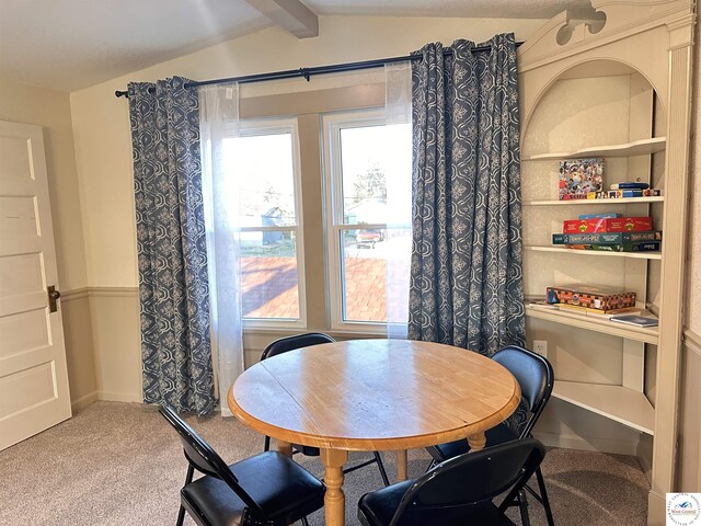 dining room with lofted ceiling with beams and carpet