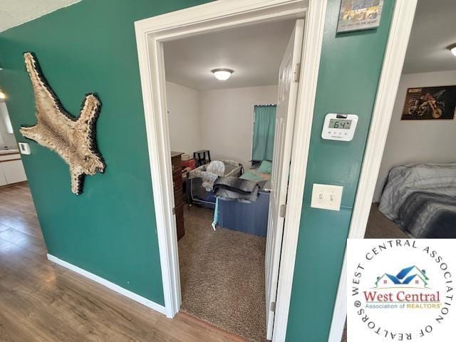 hallway featuring baseboards and wood finished floors