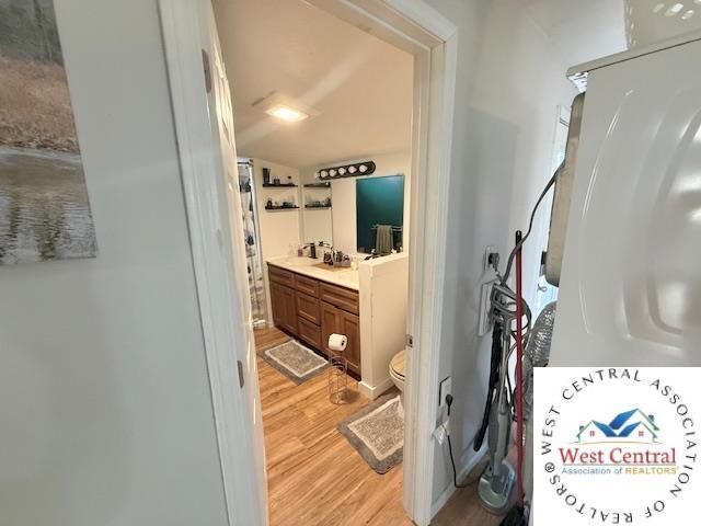 bathroom with vanity, toilet, and wood finished floors