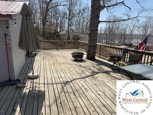 wooden terrace featuring a fire pit