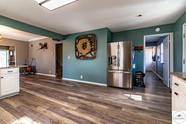 kitchen with white cabinets, dark stone counters, stainless steel refrigerator with ice dispenser, and dark wood-type flooring