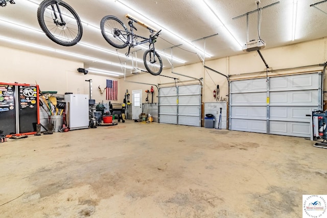 garage with freestanding refrigerator and a garage door opener