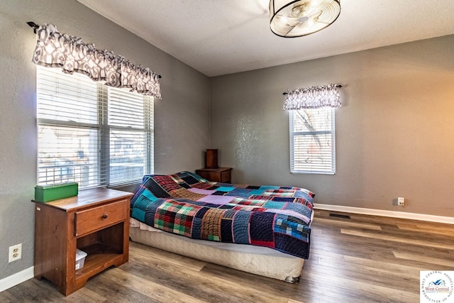 bedroom with baseboards and wood finished floors