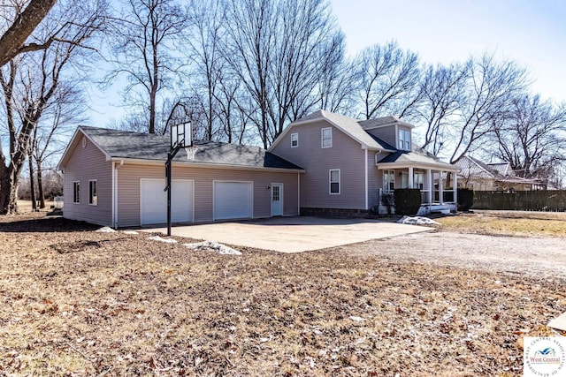 view of property exterior featuring covered porch, concrete driveway, fence, and a garage