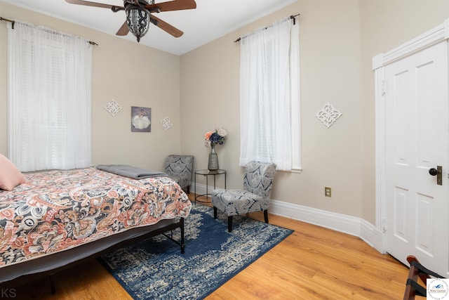 bedroom with a ceiling fan, baseboards, and wood finished floors