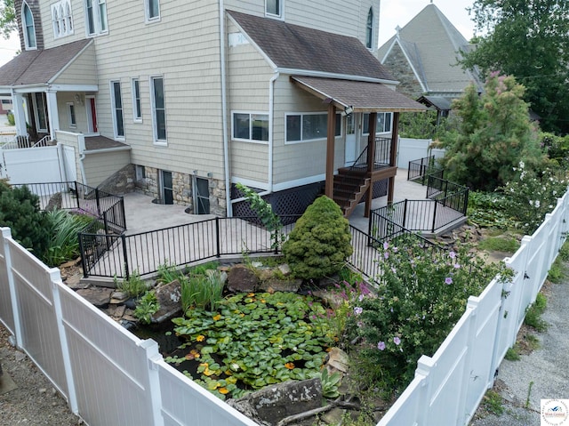 view of home's exterior with a shingled roof and fence private yard