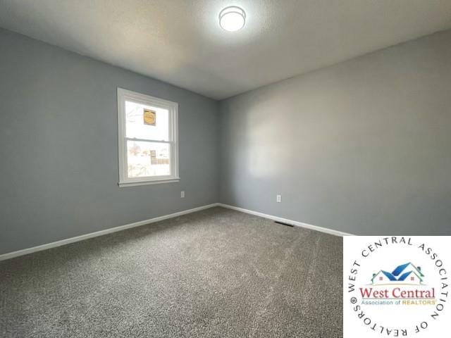 empty room featuring carpet floors and baseboards