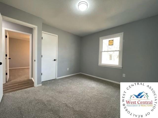 unfurnished bedroom with baseboards and carpet flooring