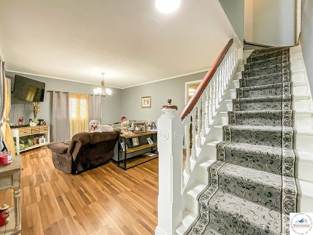 living room featuring a chandelier, stairway, wood finished floors, and crown molding