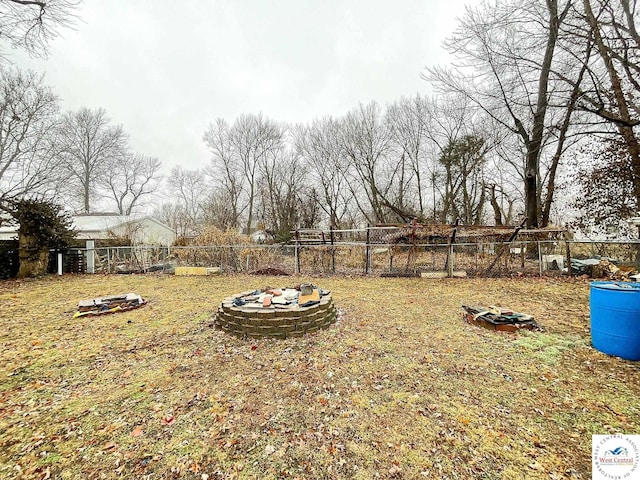 view of yard featuring an outdoor fire pit and fence