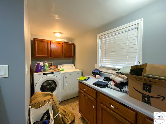 laundry area featuring light tile patterned floors, washer and clothes dryer, and cabinet space