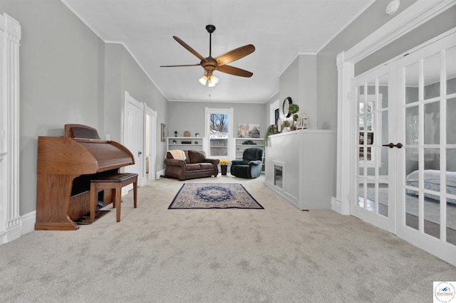 living room with french doors, carpet flooring, crown molding, and ceiling fan