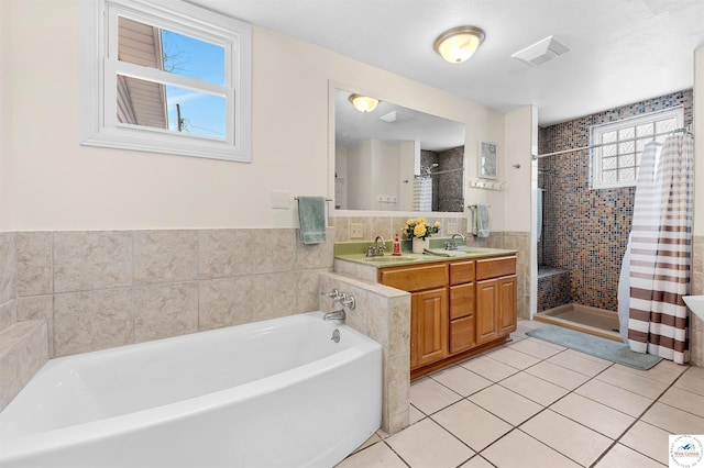 full bath featuring visible vents, tile patterned floors, a garden tub, a shower stall, and a sink