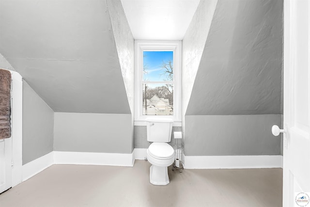 bathroom featuring toilet, vaulted ceiling, and baseboards