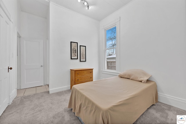 bedroom with light carpet, crown molding, and baseboards