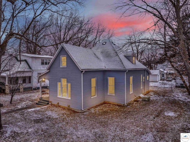 back of house with a shingled roof