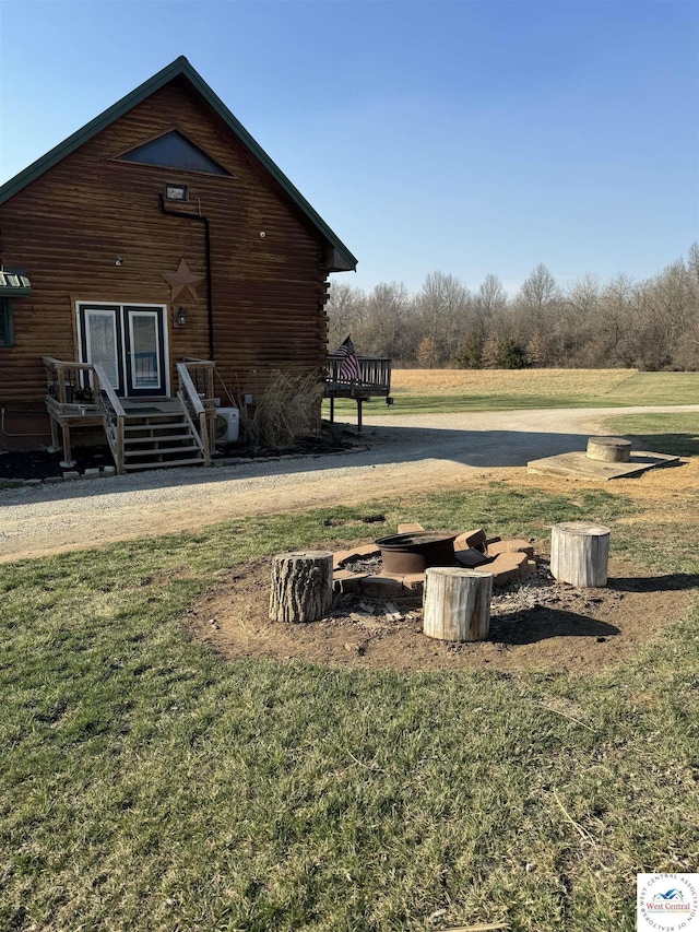 view of home's exterior featuring a lawn and log siding