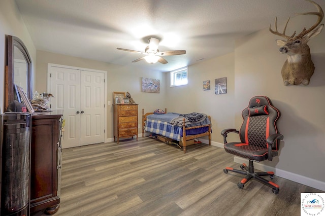 bedroom with a closet, baseboards, and wood finished floors