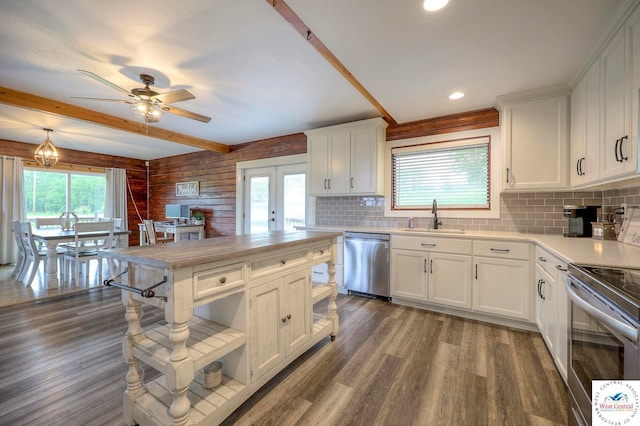 kitchen with white cabinets, wood finished floors, stainless steel appliances, light countertops, and a sink