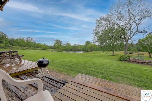 deck with a water view and a yard