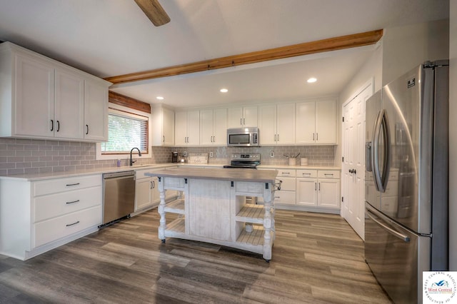 kitchen featuring appliances with stainless steel finishes, a center island, white cabinets, and light countertops