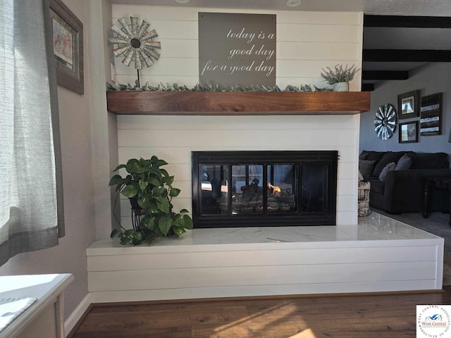 room details with wood finished floors and a multi sided fireplace