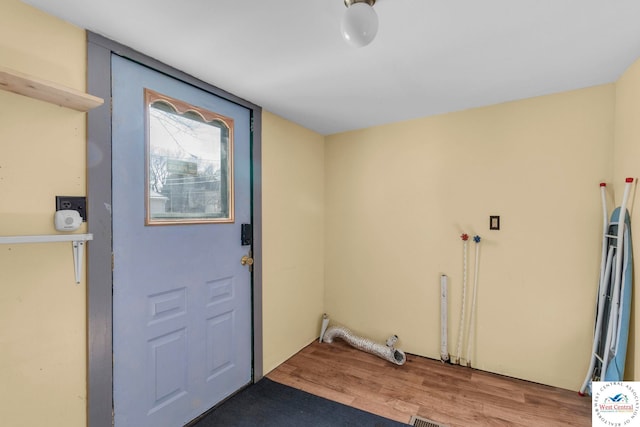 interior space with laundry area and wood finished floors