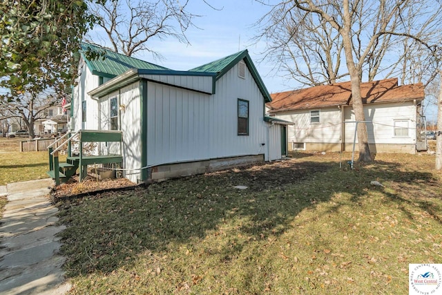 view of property exterior featuring metal roof and a yard