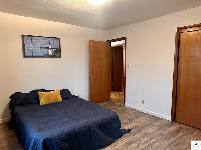 bedroom with baseboards and wood finished floors