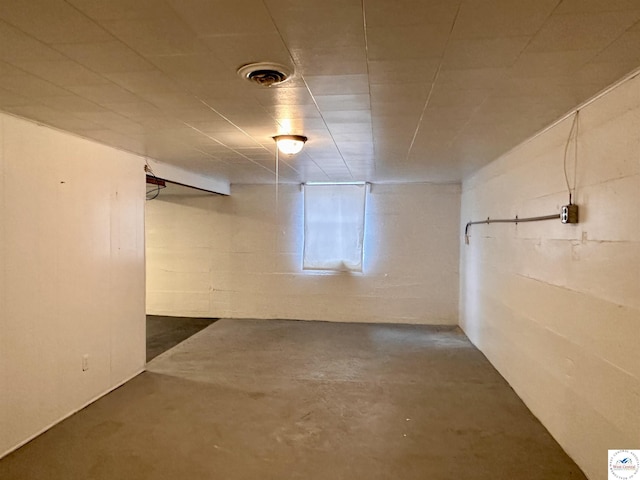 finished basement featuring visible vents and concrete block wall