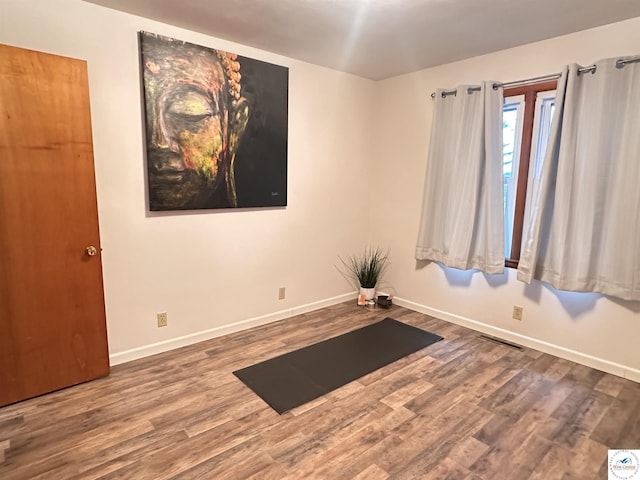 exercise area featuring visible vents, baseboards, and wood finished floors