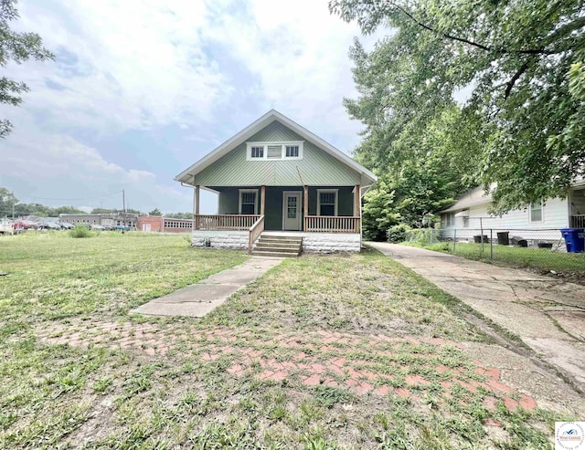 bungalow-style house featuring a porch, a front yard, and fence