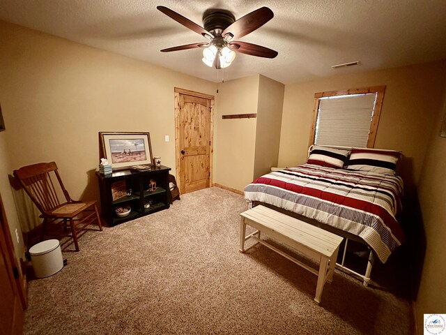 bedroom featuring ceiling fan, visible vents, a textured ceiling, and carpet flooring