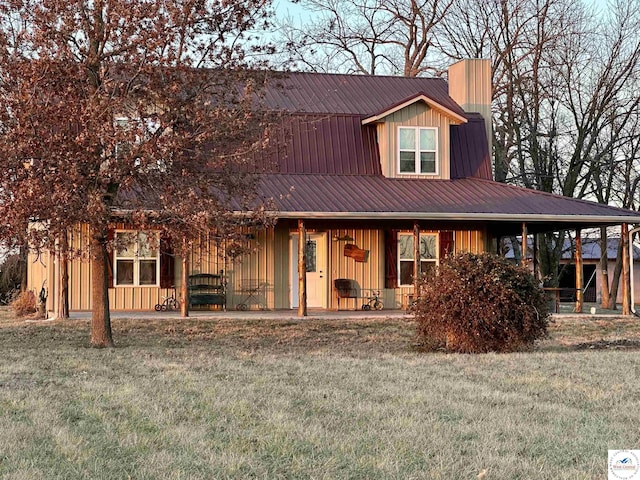 view of front of property with metal roof, board and batten siding, and a front yard