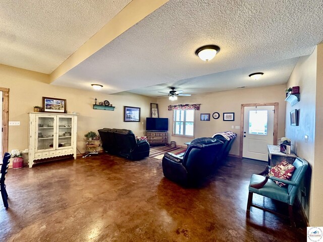 living area featuring a textured ceiling, concrete floors, and a ceiling fan