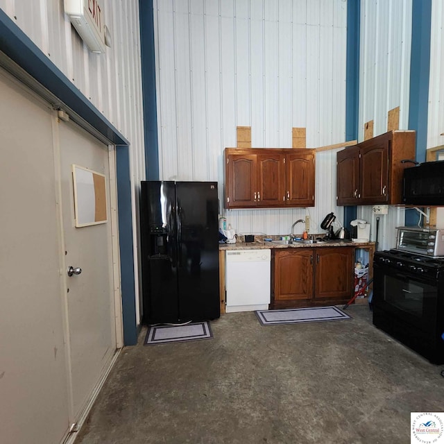 kitchen with unfinished concrete flooring, a sink, and black appliances