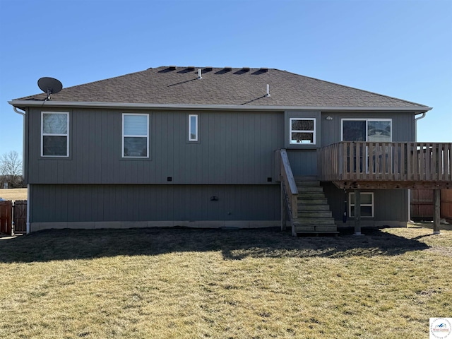 rear view of house featuring a yard, a shingled roof, stairway, fence, and a wooden deck