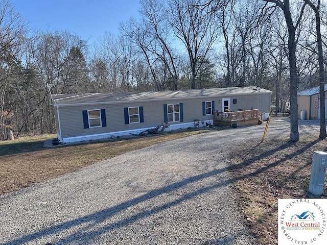 view of front of home with gravel driveway and a wooden deck