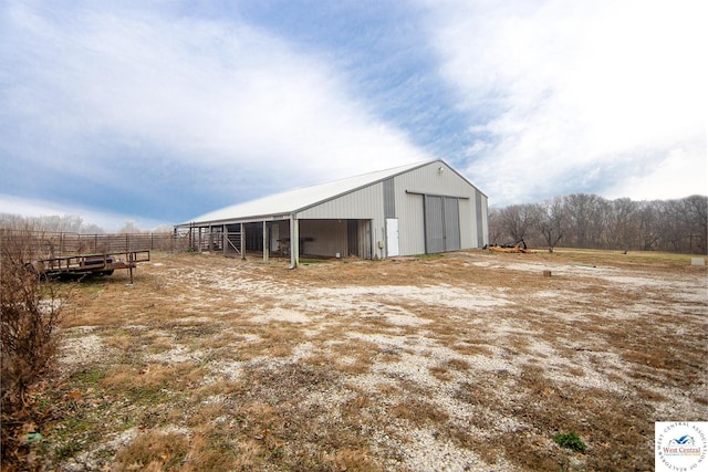 view of pole building with a rural view and fence