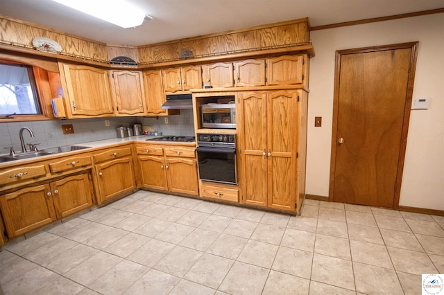 kitchen featuring brown cabinets, stainless steel appliances, light countertops, decorative backsplash, and a sink