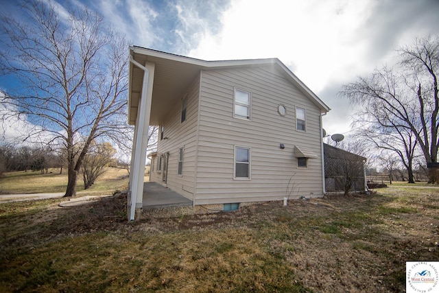 view of home's exterior with a patio area and a yard