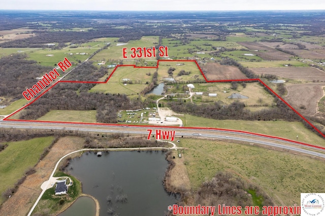 birds eye view of property featuring a water view and a rural view