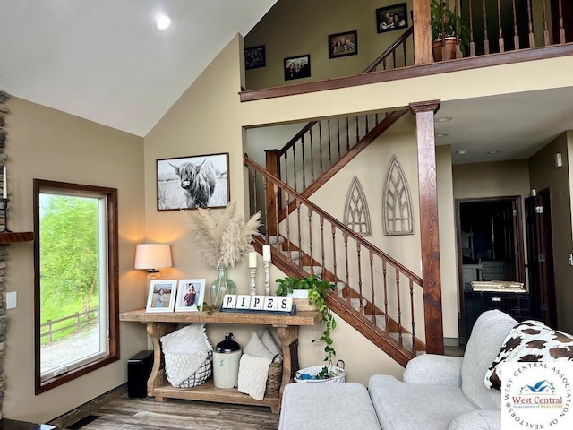 stairs featuring high vaulted ceiling and wood finished floors