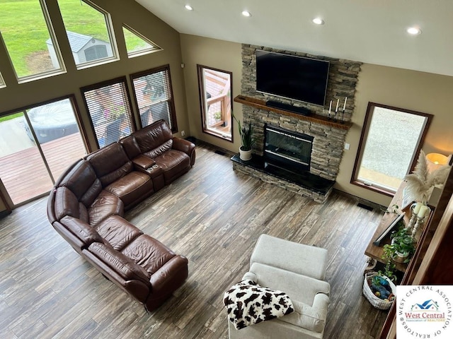 living room featuring lofted ceiling, a fireplace, recessed lighting, and wood finished floors