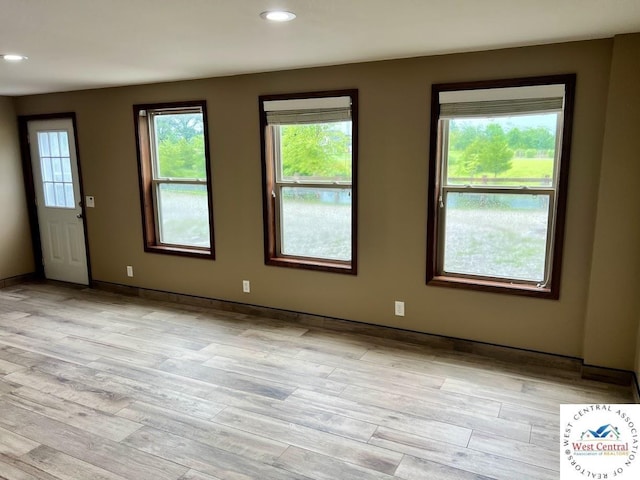 empty room with light wood-style flooring and recessed lighting