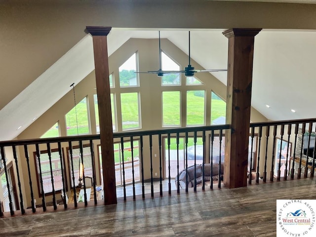 interior space featuring decorative columns, a ceiling fan, and wood finished floors