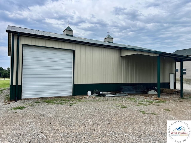 exterior space with a detached garage and an outbuilding